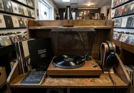 Vinilos y cuadernos de letras ordenados junto a una mesa de escucha